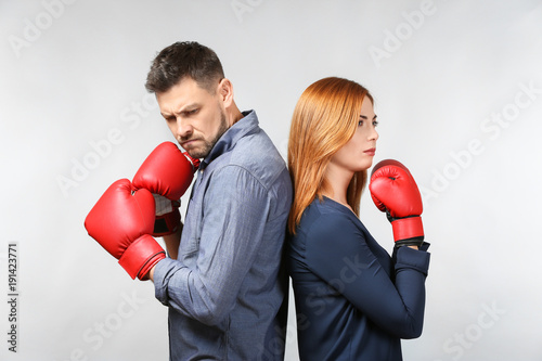 Quadro su tela Angry couple in boxing gloves on light background