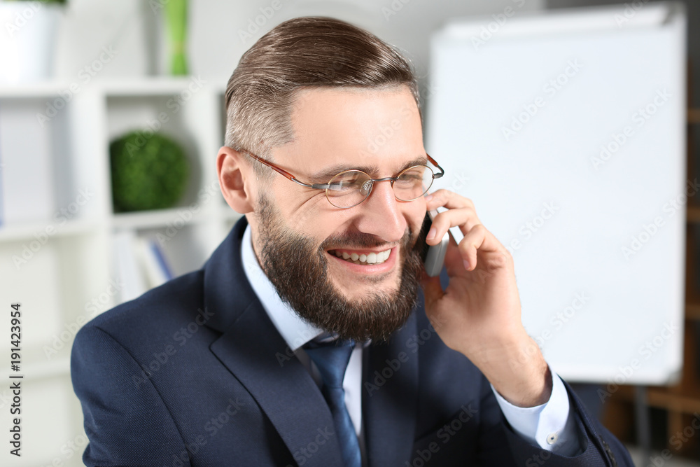 Handsome businessman talking on cell phone indoors Handsome businessman talking on cell phone indoors
