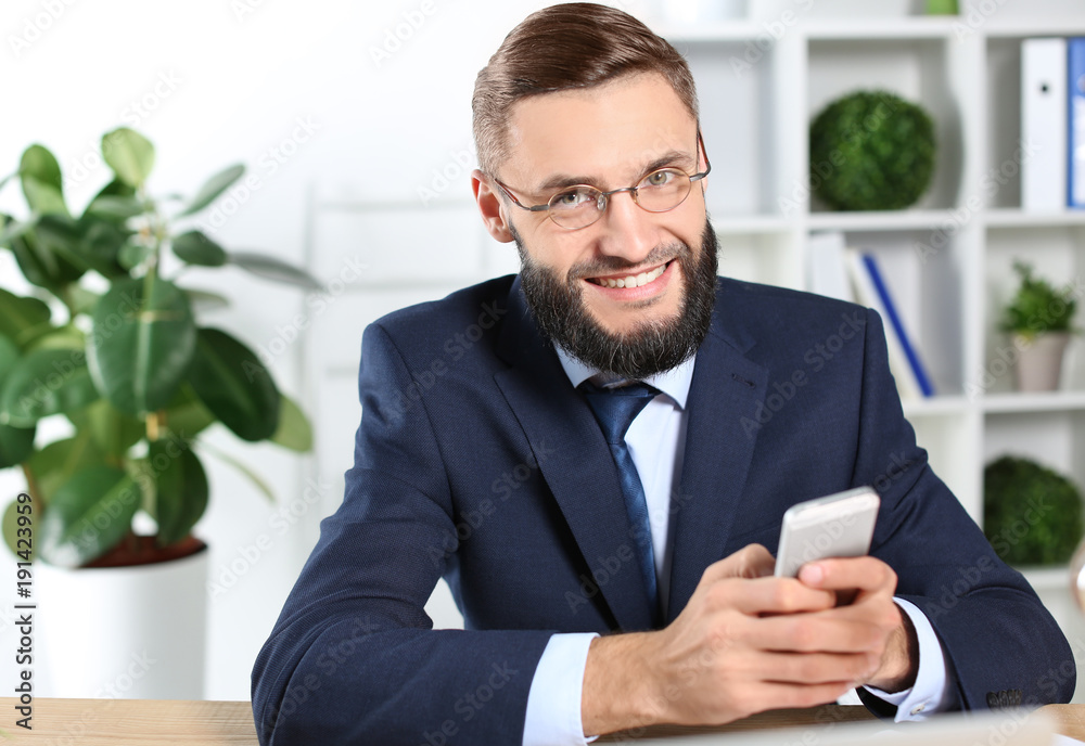 Portrait of handsome businessman with cell phone indoors Portrait of handsome businessman with cell phone indoors
