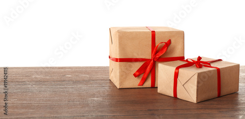 Parcel gift boxes on wooden table against white background
