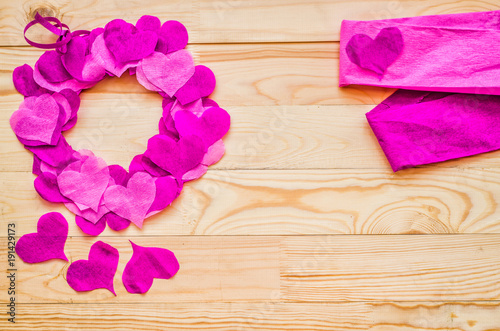 valentine day concept. a wreath decorated with purple and pink crepe paper hearts with pink paper with copy space