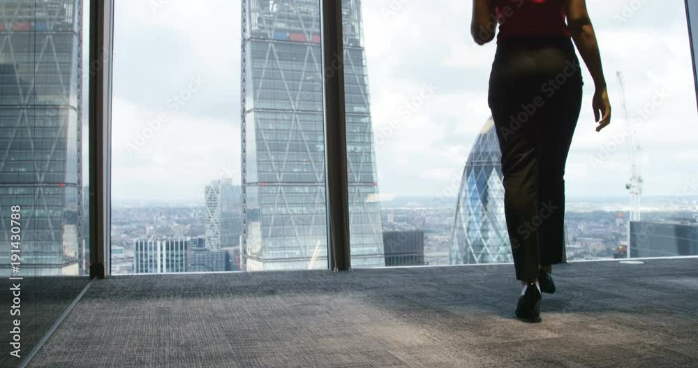 4K Successful African American businesswoman in British office goes to window to look at view of London skyline. Slow motion. 4K Successful African American businesswoman in British office goes to window to look at view of London skyline. Slow motion.