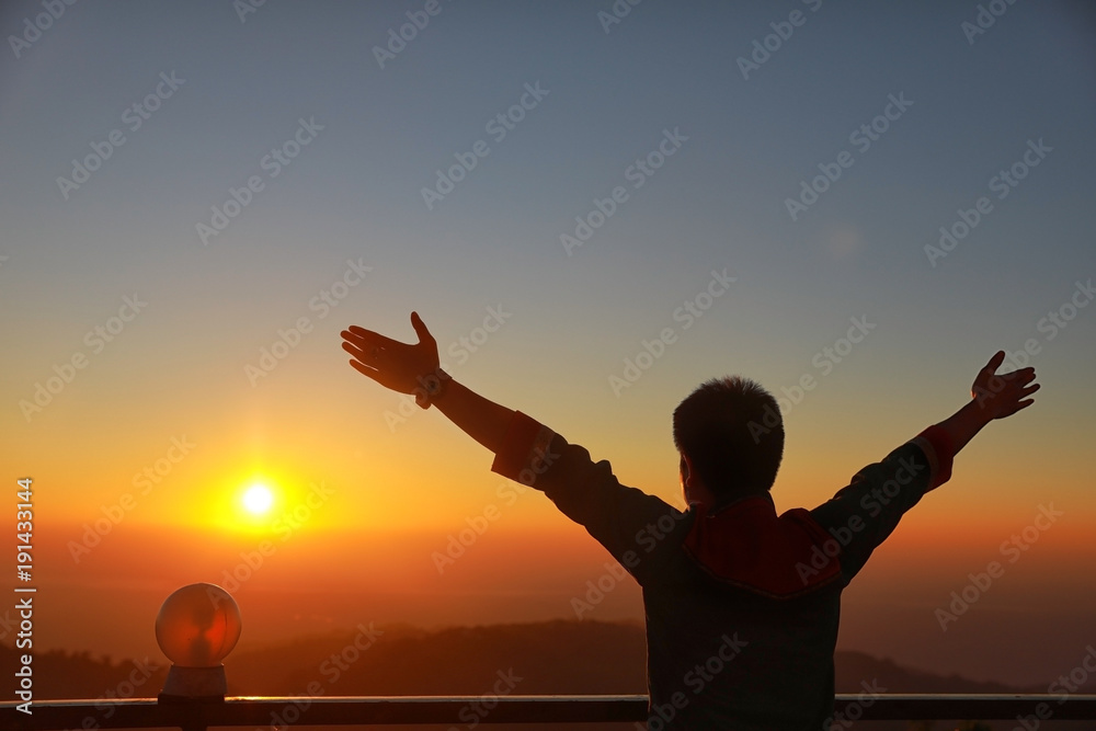 Happy Businessman show hand up for successful at beautiful sunset time, Silhouette the man hand  at sunset,Silhouette of Man Raising His Hands or Open arms when sunset.