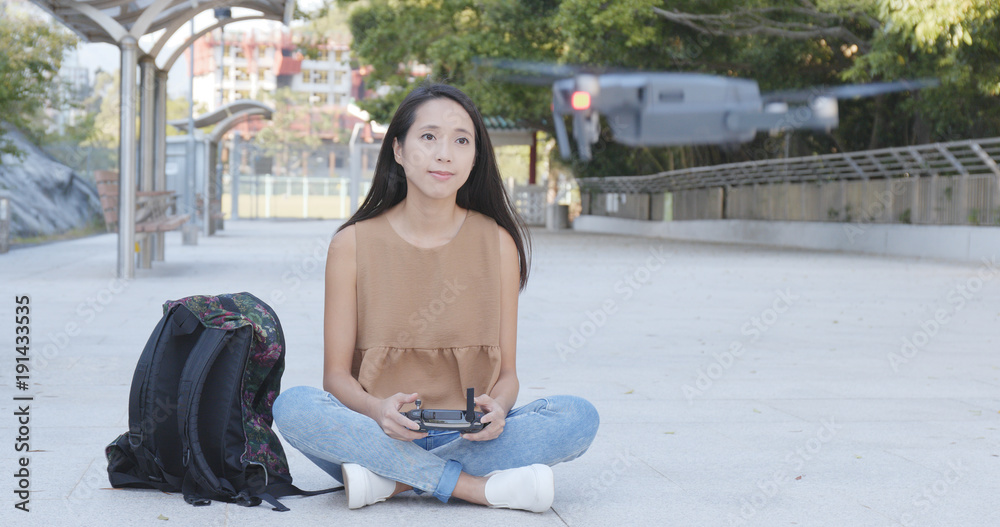 Fototapeta premium Asian Woman control flying drone