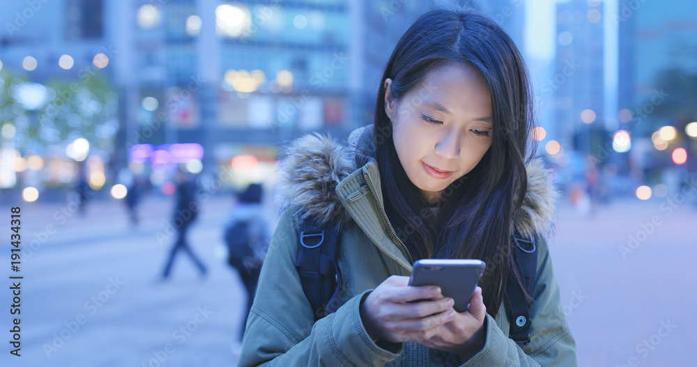 Woman use of cellphone in city at night Woman use of cellphone in city at night