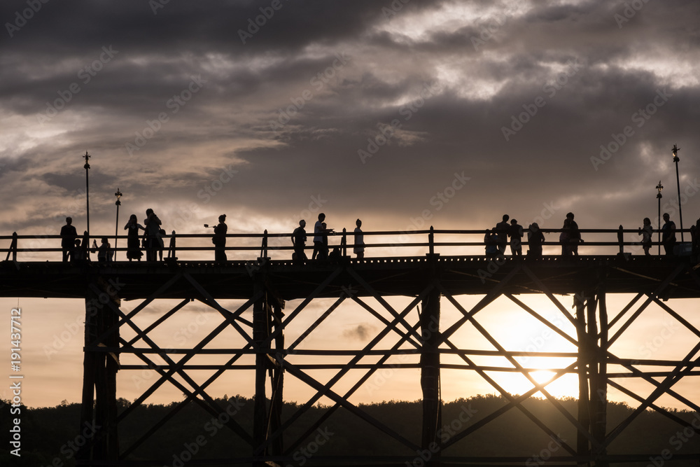 Silhouette tourists travel walking on wooden mon bridge