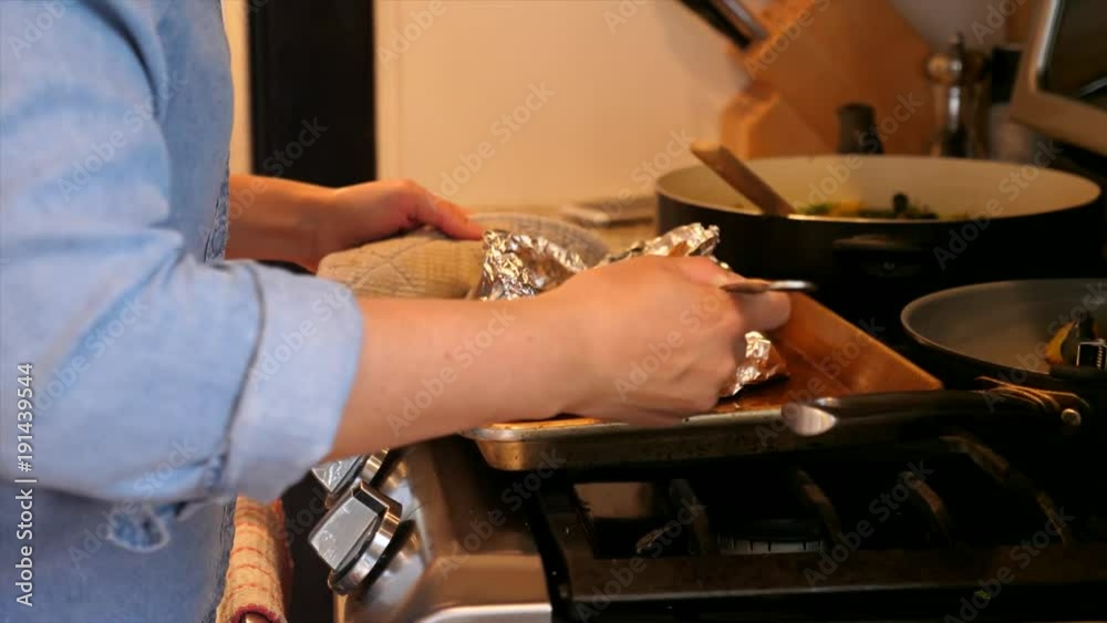 A woman prepares a salmon dinner with vegetables A woman prepares a salmon dinner with vegetables