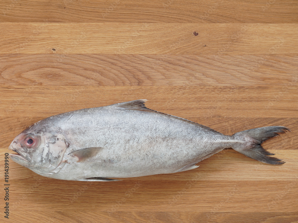 Raw trevally fish on wooden cutting board background Raw trevally fish on wooden cutting board background