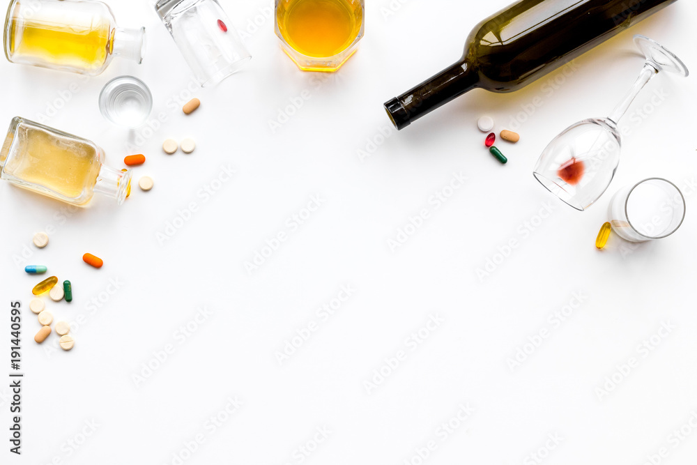Alcoholism treatment. Glasses, bottles and pills on white background top view copy space
