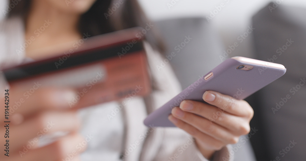 Woman having online shopping on cellphone and credit card