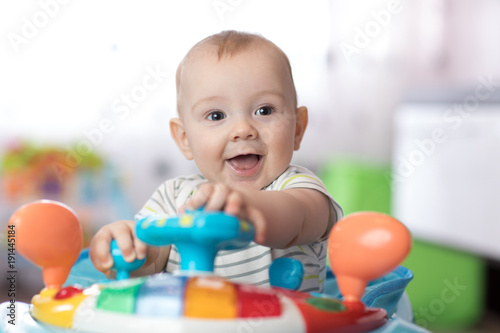 Portrait of baby playing in baby walker