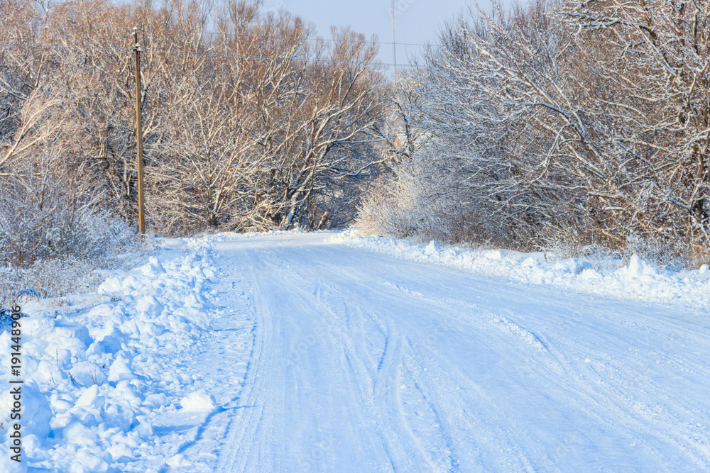 Obraz premium Snowy road after snowfall. Winter rural landscape