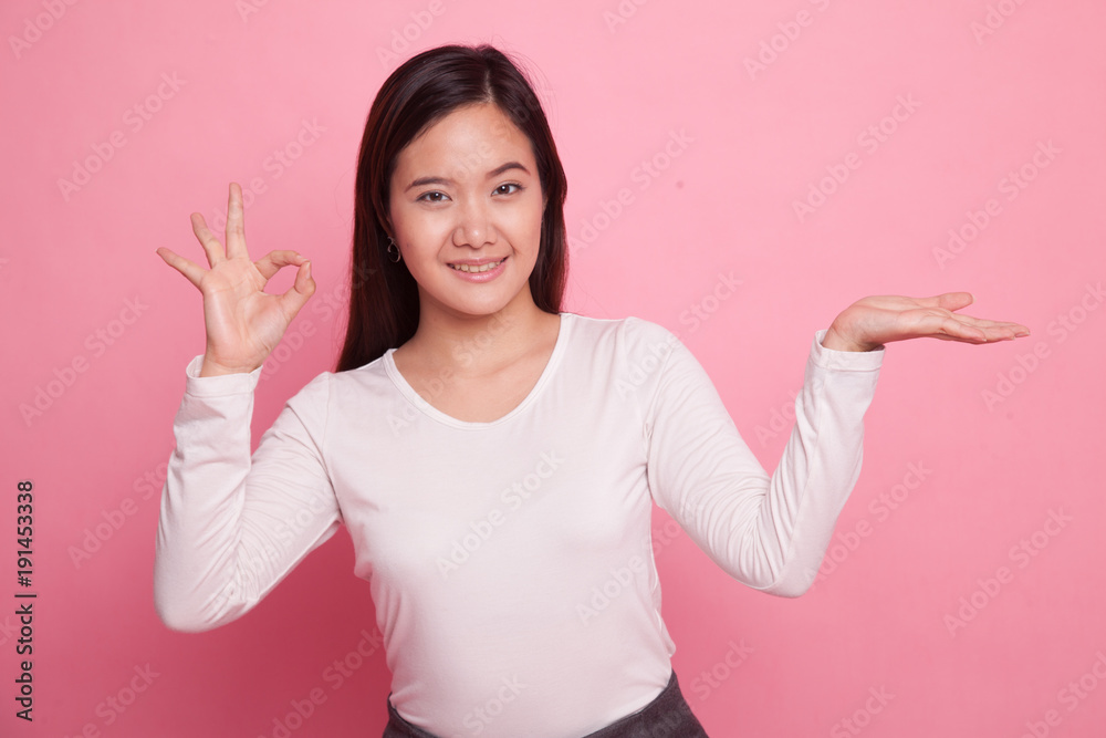 Beautiful young Asian woman show palm hand and OK sign. Beautiful young Asian woman show palm hand and OK sign.