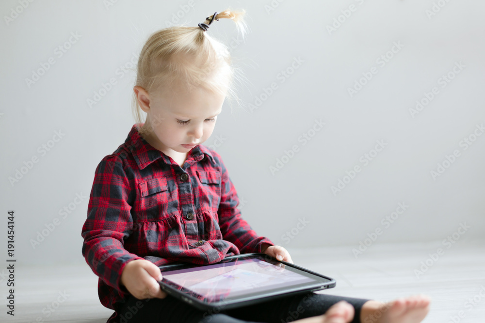 Little cute girl watching a cartoon on the tablet. Little cute girl watching a cartoon on the tablet.