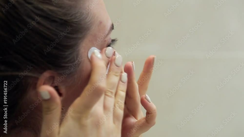 A young woman with a smile demonstrates the method of applying patches to the area around the eyes. A young woman with a smile demonstrates the method of applying patches to the area around the eyes.