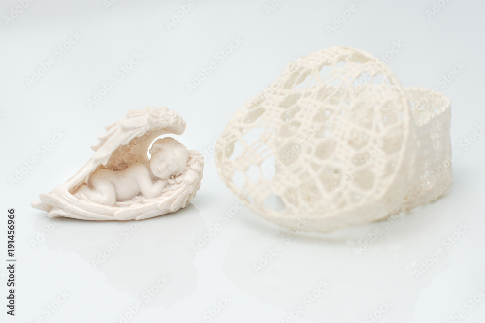 Heart shaped box on a white background at an angel figurines Heart shaped box on a white background at an angel figurines