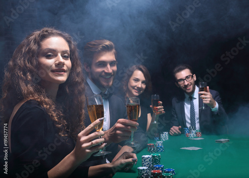 group of friends sitting at game table in casino