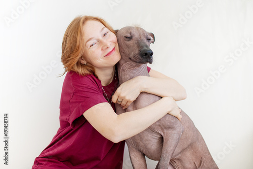 A woman hugging with a Mexican Hairless Dog