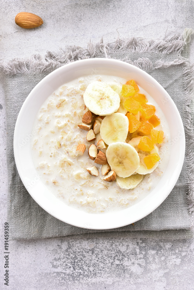 Oatmeal porridge with banana slices, almond and dried apricot
