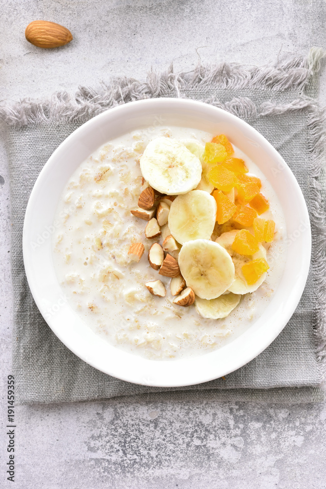 Oatmeal porridge with banana slices, almond and dried apricot Oatmeal porridge with banana slices, almond and dried apricot