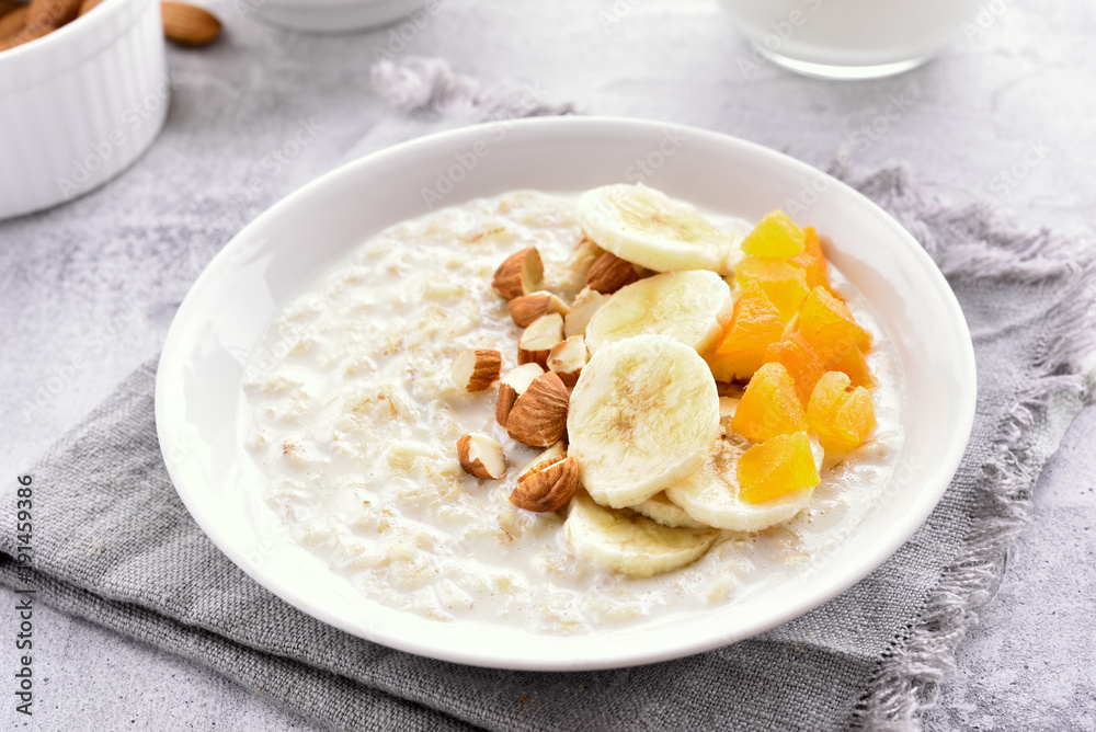 Oats porridge with banana slices, nuts and dried apricot Oats porridge with banana slices, nuts and dried apricot