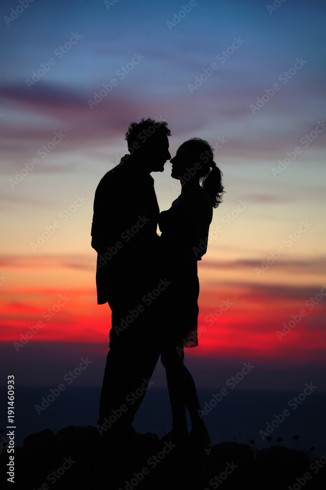 Silhouette of a loving couple against the sky after sunset