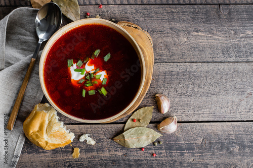 Homemade Traditional Ukrainian National soup on Wooden Old Rustic Table Background. Red beetrot soup with vegetables and meat. Top view, copy space.
