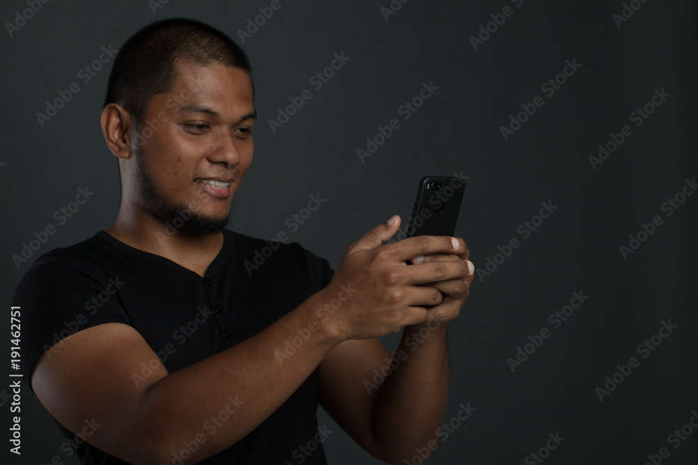 man using gadget with different expression in gray background man using gadget with different expression in gray background
