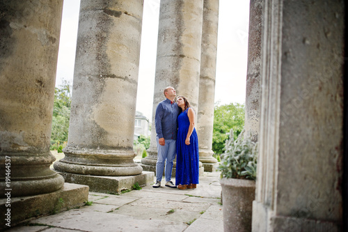 Lovely couple in love against old castle. Girl in blue dress.