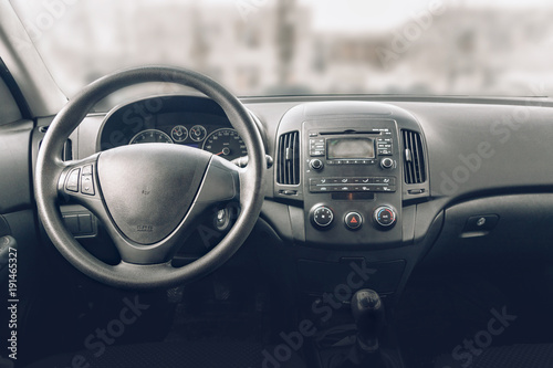 Obraz na płótnie Car inside driver place. Interior of modern car.e Steering wheel, dashboard, display climate control. Black cockpit w salonie