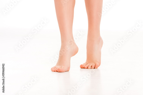 low section of barefoot female legs  isolated on white