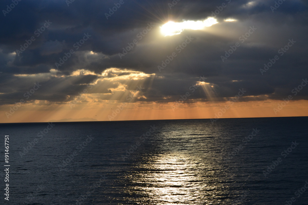 sonnenuntergang über dem Meer, Sonnenstrahlen zwischen den Wolken