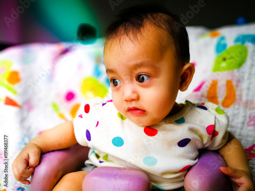 Candid portrait of a cute and expressive Asian baby girl. Lifestyle and childhood concept.