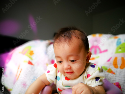 Candid portrait of a cute and expressive Asian baby girl. Lifestyle and childhood concept.