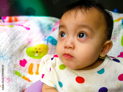 Candid portrait of a cute and expressive Asian baby girl. Lifestyle and childhood concept.