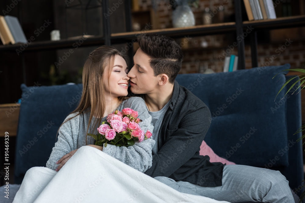 boyfriend going to kiss girlfriend with bouquet of roses, international womens day concept