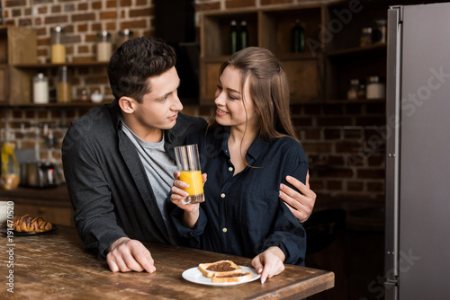 boyfriend hugging girlfriend with orange juice