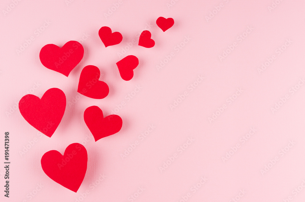 Red paper hearts soar on pink color background, copy space. Valentines day backdrop.