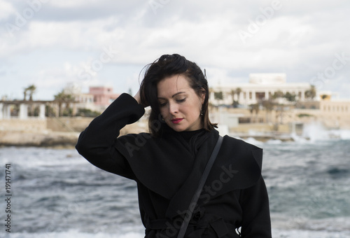 The woman in grief in black clothes, on the sea coast © julijacernjaka