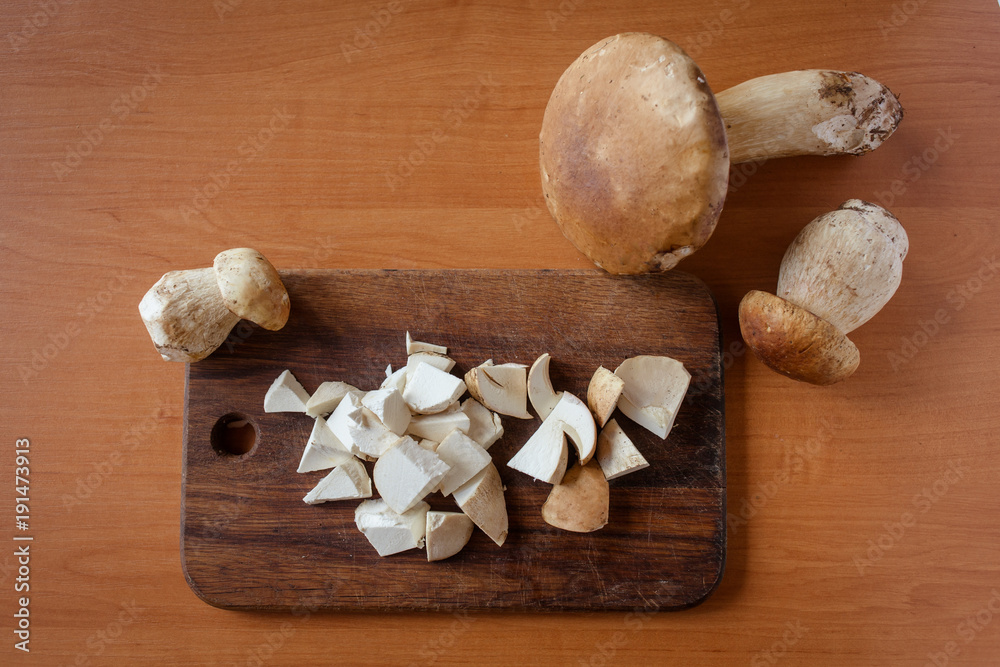 Big white mushroom and chopped mushrooms on a wooden board