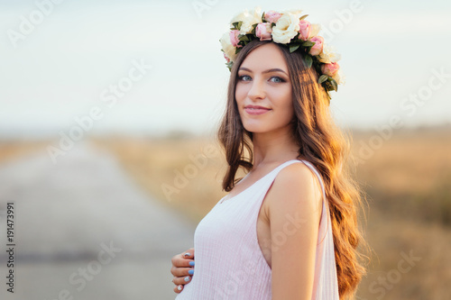 The charming girl stands in the field