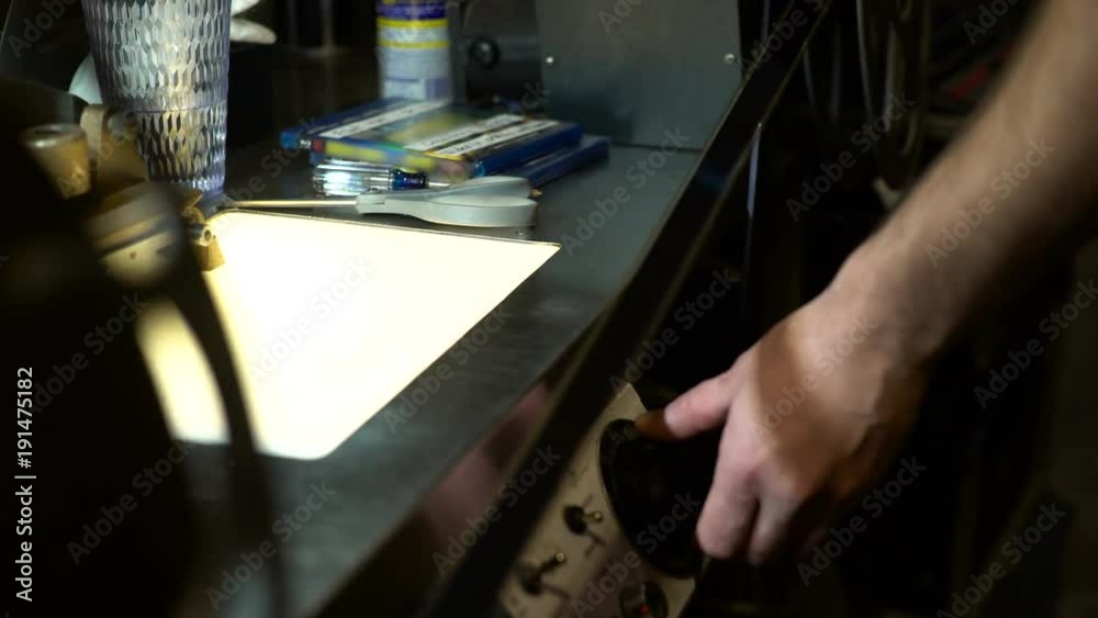 Close up of hands inspecting 35mm film for archival storage. Close up of hands inspecting 35mm film for archival storage.