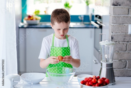 Child boy cracking egg and separating the yolk