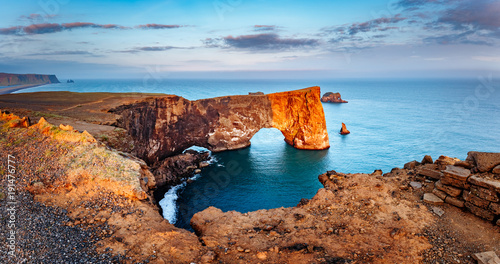 Amazing black arch of lava standing in the sea. Location cape Dyrholaey, Iceland, Europe. photo