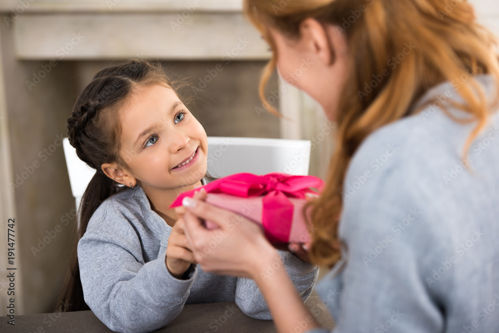 selective focus of adorable smiling child presenting gift box to mother selective focus of adorable smiling child presenting gift box to mother