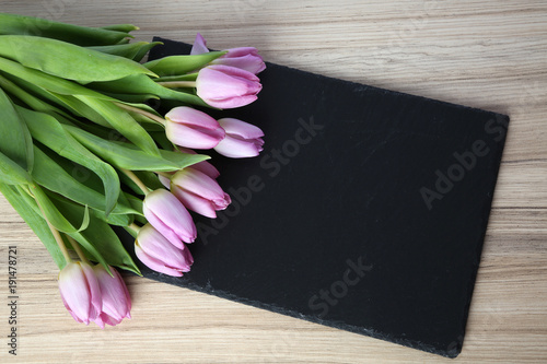 bunte tulpen auf schwarzer schiefersteinplatte