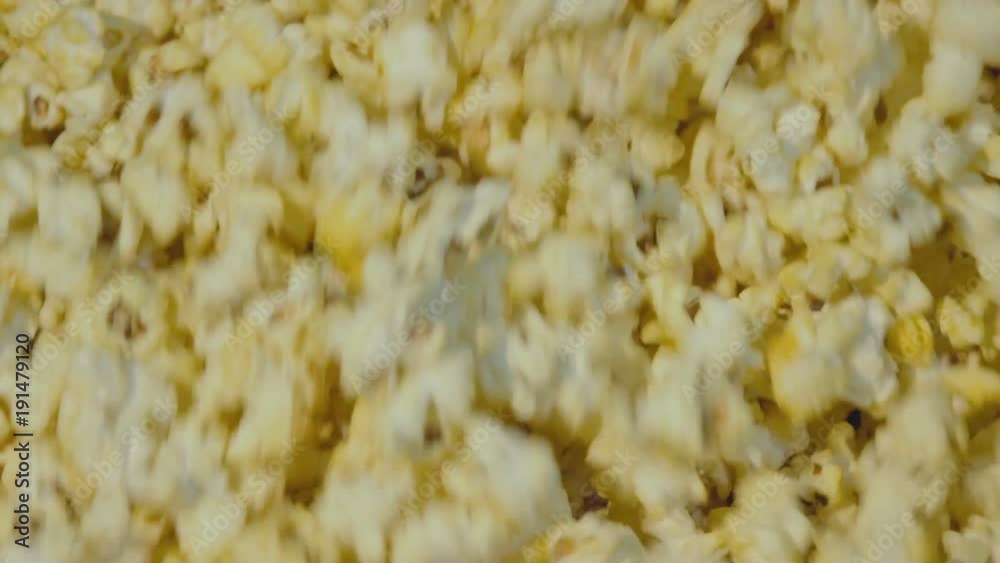 View of popcorn circling in the bowl during the cooking. Slowly View of popcorn circling in the bowl during the cooking. Slowly