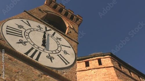 Medieval tower in a castle with a nice white clock, filmed from left to right. photo