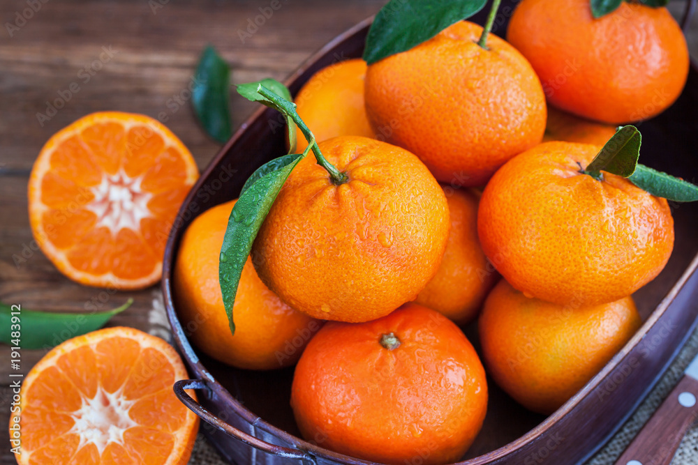 Fresh tangerines with leaves on wooden table Fresh tangerines with leaves on wooden table