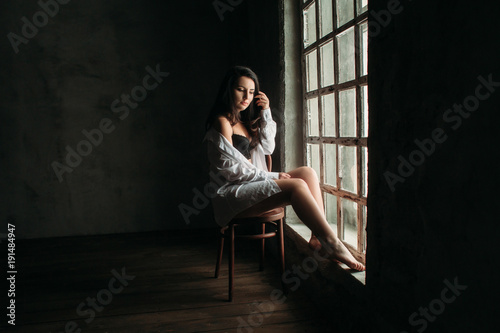 The beautiful girl sits on the chair  near window © kristina_1994